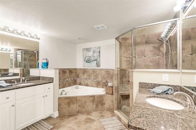 bathroom featuring a textured ceiling, vanity, and plus walk in shower