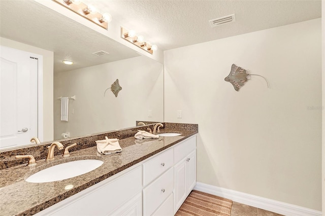 bathroom with vanity, tile patterned floors, and a textured ceiling