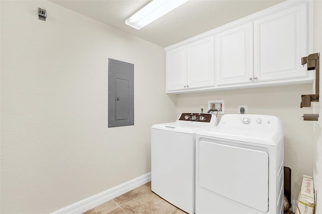 laundry room featuring light tile patterned floors, cabinets, electric panel, and washing machine and clothes dryer