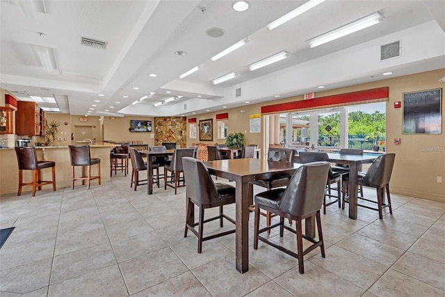 tiled dining space featuring a tray ceiling