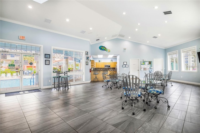 dining area featuring crown molding and high vaulted ceiling