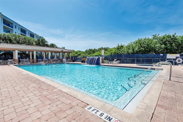 view of swimming pool with pool water feature and a patio