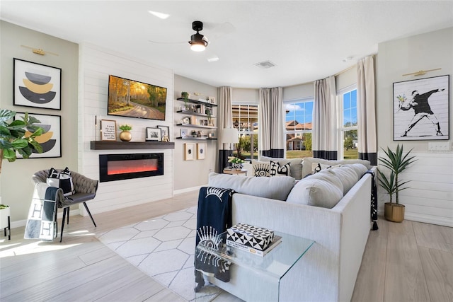 living room with a large fireplace and light hardwood / wood-style floors