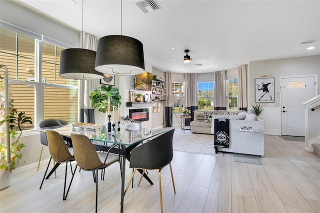 dining room with a fireplace, a wealth of natural light, and ceiling fan