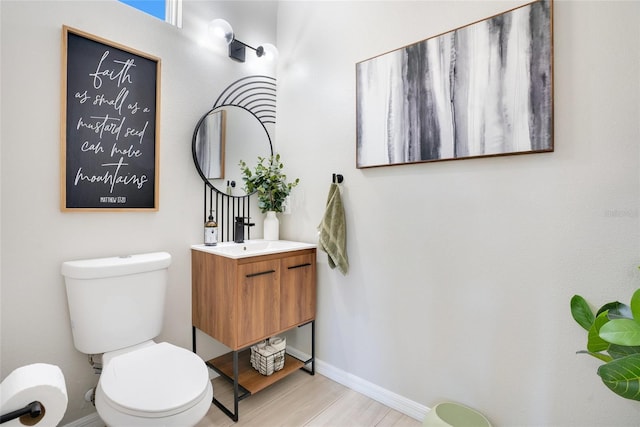 bathroom with hardwood / wood-style floors, vanity, and toilet