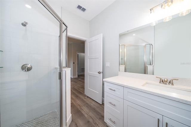 bathroom featuring vanity, walk in shower, and hardwood / wood-style floors