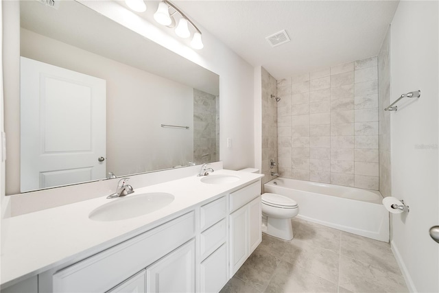 full bathroom featuring toilet, vanity, and tiled shower / bath combo