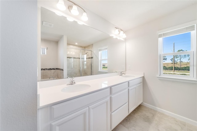 bathroom featuring an enclosed shower, a healthy amount of sunlight, and vanity