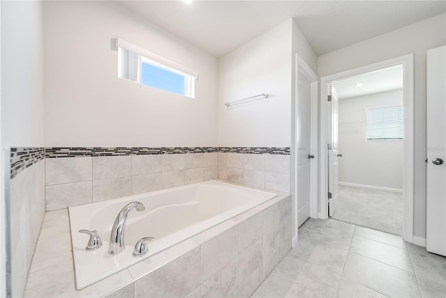 bathroom with tiled bath and tile patterned floors