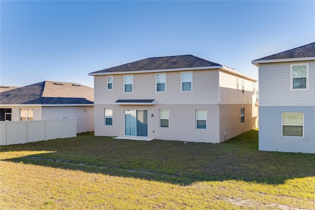 rear view of property featuring a yard