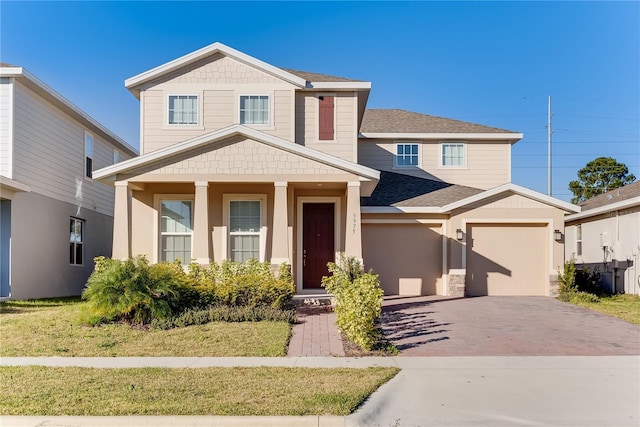 view of front of property featuring a porch, a front lawn, and a garage