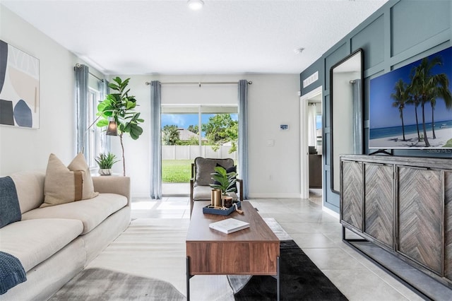 tiled living room with a textured ceiling and a healthy amount of sunlight