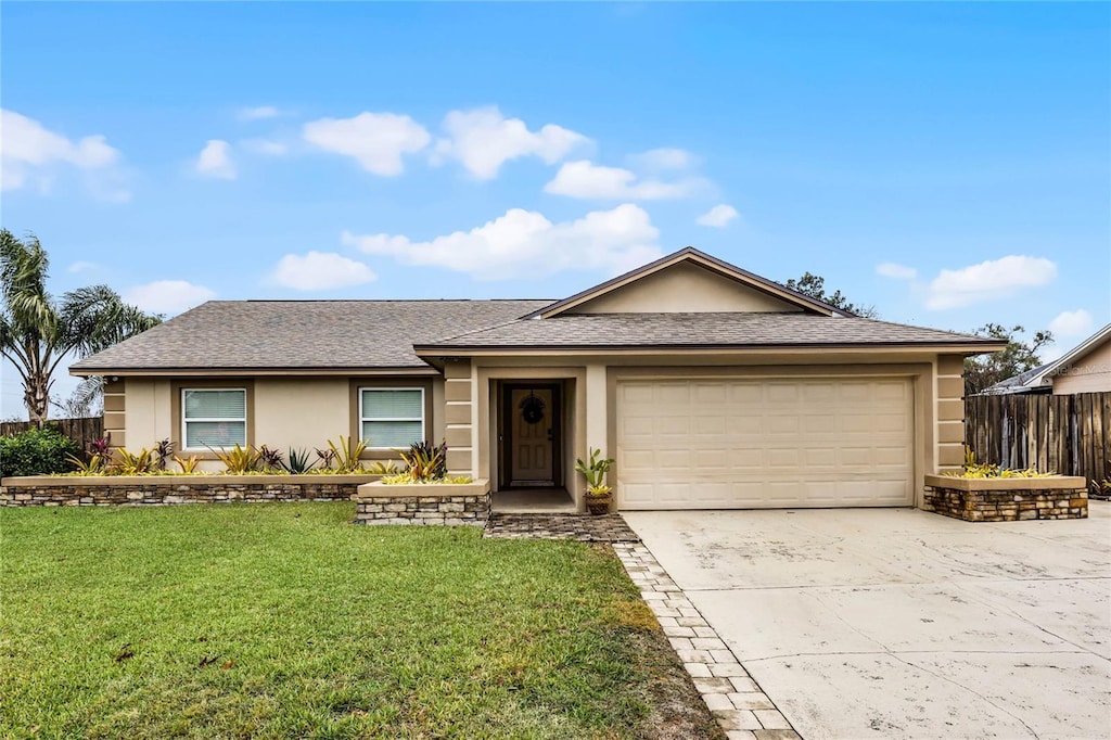 ranch-style home with a garage and a front lawn