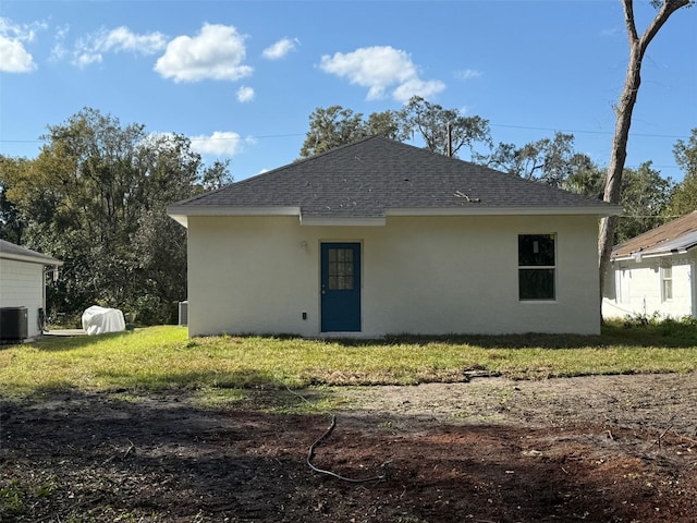 back of property featuring a yard and central AC