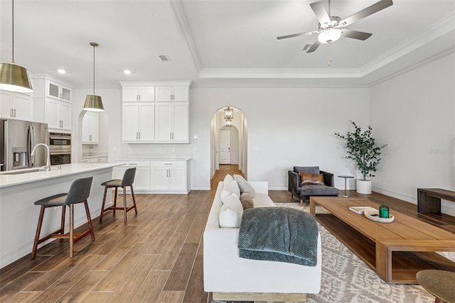 living room with ceiling fan and ornamental molding