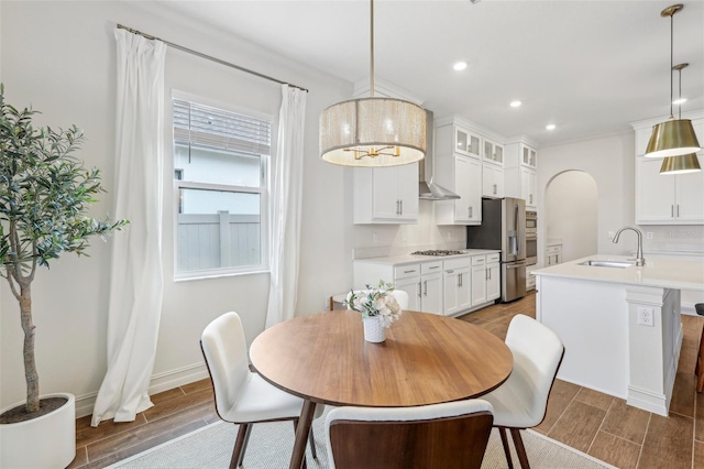 dining space with sink and crown molding