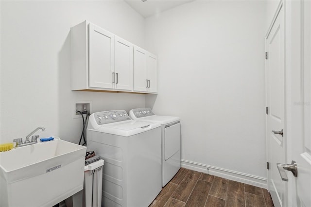 clothes washing area featuring independent washer and dryer, sink, and cabinets