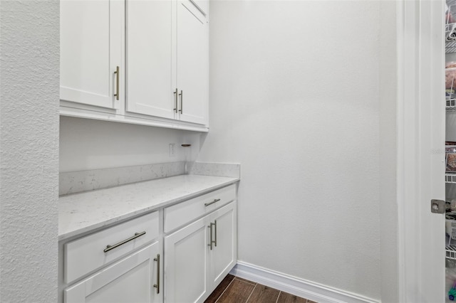 bar with light stone counters and white cabinetry