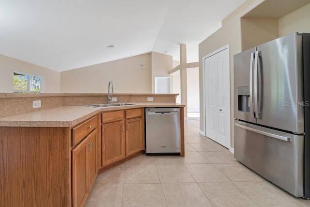 kitchen with sink, light tile patterned flooring, stainless steel appliances, and lofted ceiling