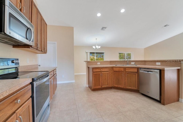 kitchen with sink, a chandelier, decorative light fixtures, light tile patterned floors, and appliances with stainless steel finishes