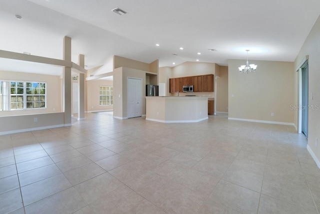 unfurnished living room with light tile patterned flooring, high vaulted ceiling, and an inviting chandelier