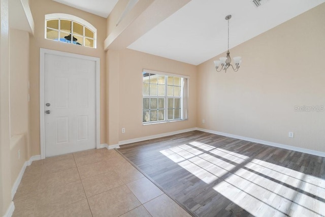 tiled entrance foyer with an inviting chandelier