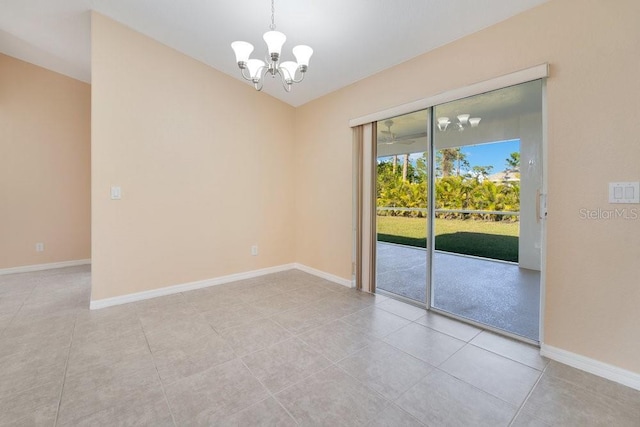 tiled spare room featuring a chandelier