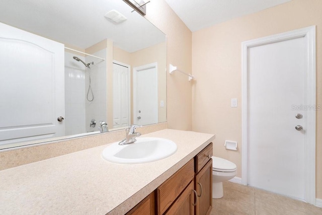 bathroom featuring a shower, tile patterned flooring, vanity, and toilet