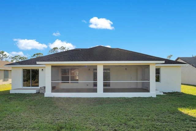 rear view of property featuring a sunroom and a yard