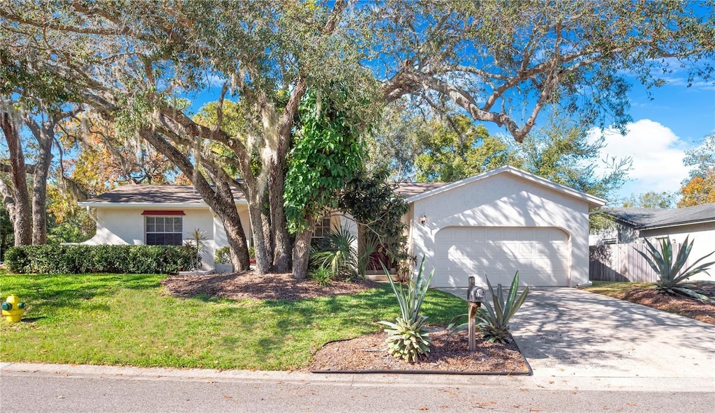 single story home featuring a garage and a front lawn