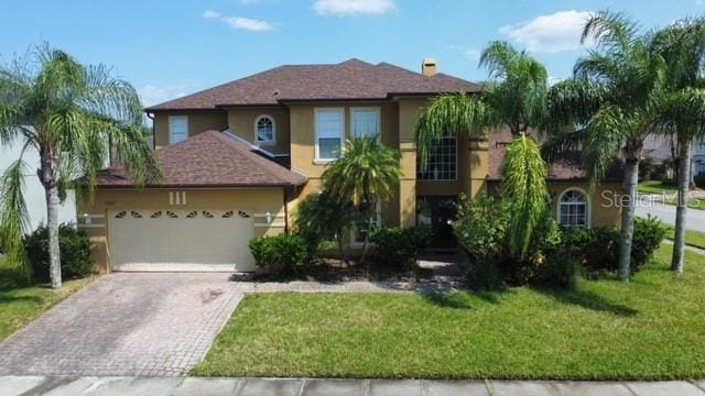 view of front of house featuring a garage and a front lawn