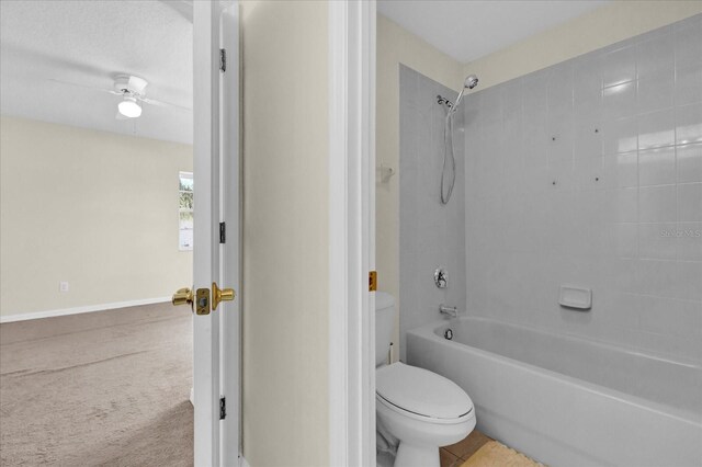 bathroom with ceiling fan, tiled shower / bath combo, and toilet