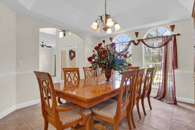 tiled dining room with a chandelier