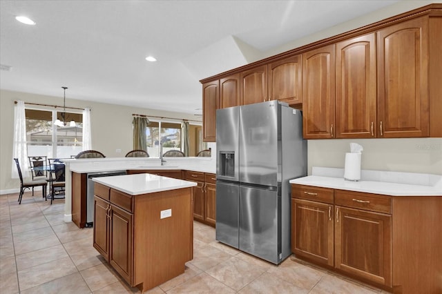 kitchen featuring pendant lighting, plenty of natural light, stainless steel appliances, and a center island