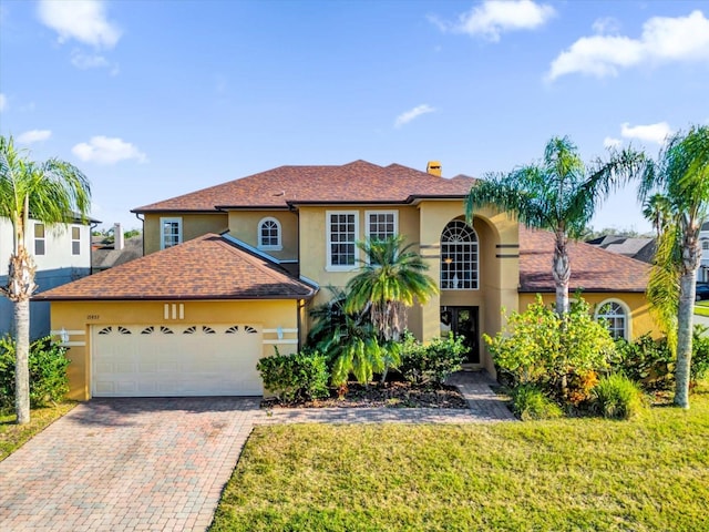 view of front of property with a garage and a front lawn