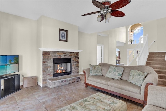 tiled living room with ceiling fan and a fireplace