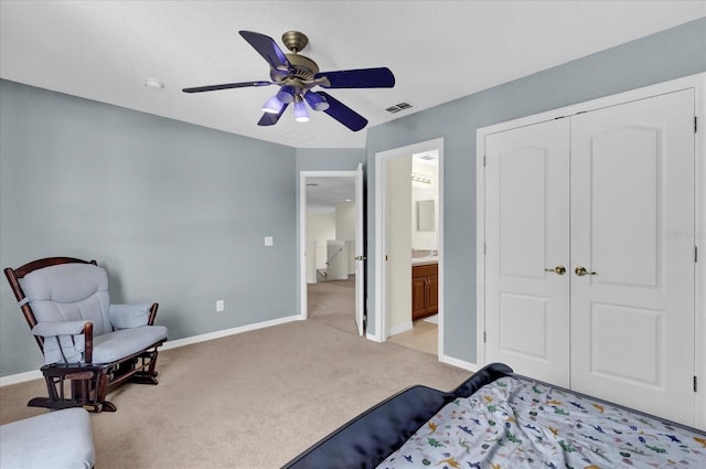 carpeted bedroom with ceiling fan, ensuite bath, and a closet