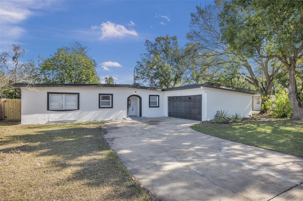 ranch-style house with a garage and a front lawn