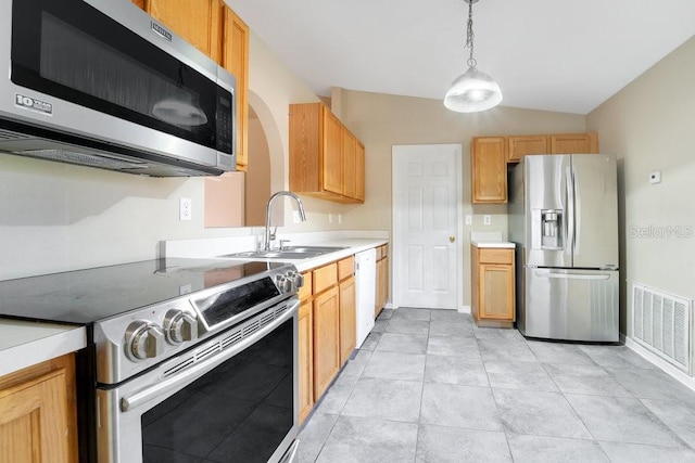 kitchen featuring sink, hanging light fixtures, stainless steel appliances, vaulted ceiling, and light brown cabinetry