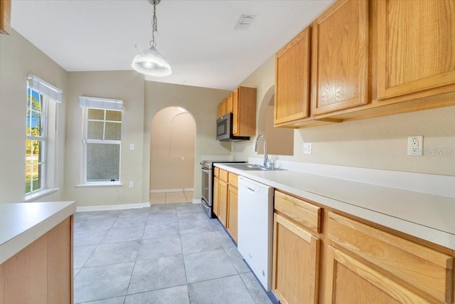 kitchen featuring sink, light tile patterned floors, decorative light fixtures, and appliances with stainless steel finishes