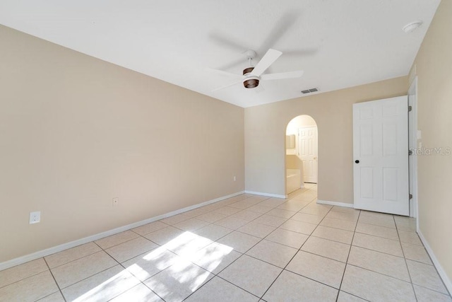 tiled spare room featuring ceiling fan