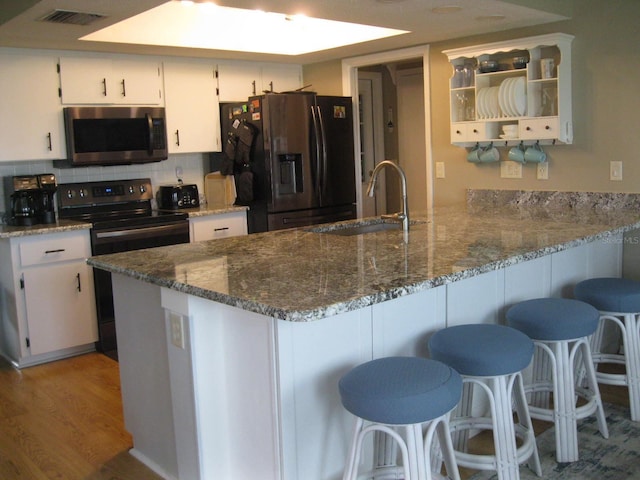 kitchen featuring white cabinets, appliances with stainless steel finishes, light hardwood / wood-style flooring, and sink