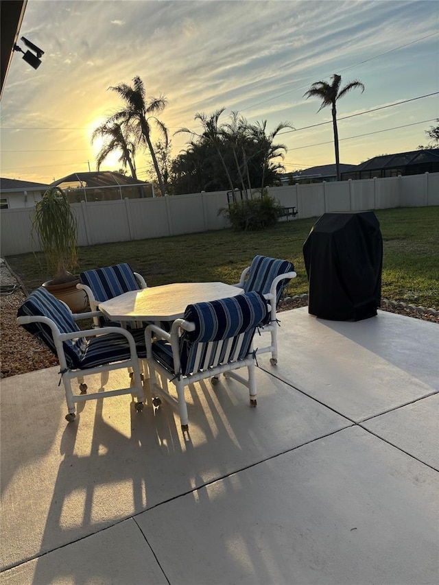 patio terrace at dusk with grilling area and a yard