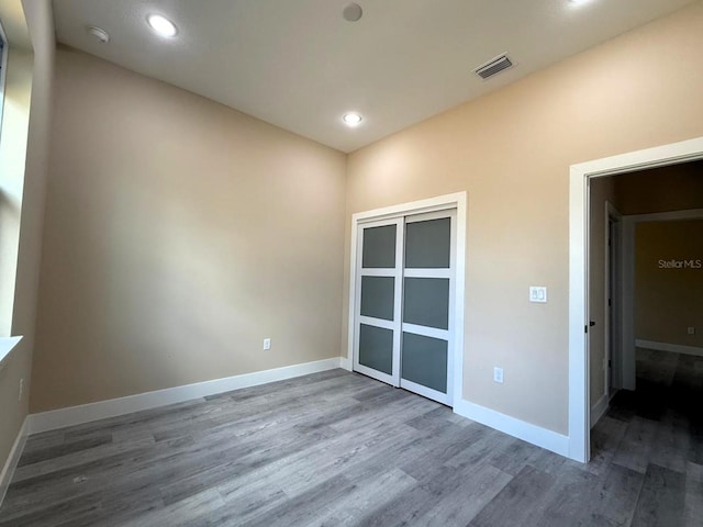 interior space featuring a closet, visible vents, baseboards, and wood finished floors