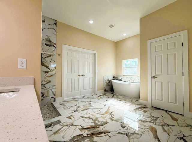 bathroom featuring marble finish floor, recessed lighting, a marble finish shower, baseboards, and a freestanding bath