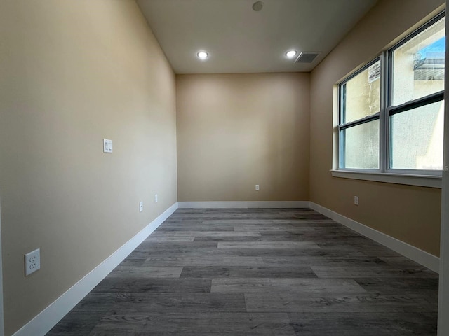 spare room featuring recessed lighting, visible vents, baseboards, and dark wood finished floors