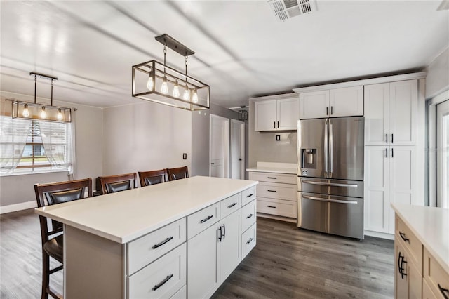 kitchen featuring decorative light fixtures, a breakfast bar area, and stainless steel refrigerator with ice dispenser