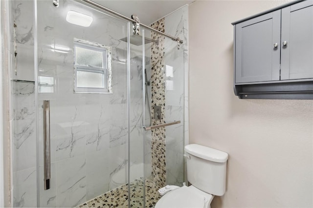 bathroom with a shower with door and toilet