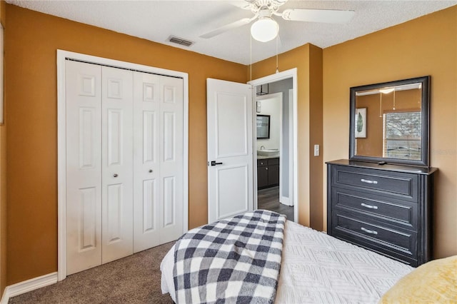 bedroom with carpet floors, sink, ceiling fan, a textured ceiling, and a closet