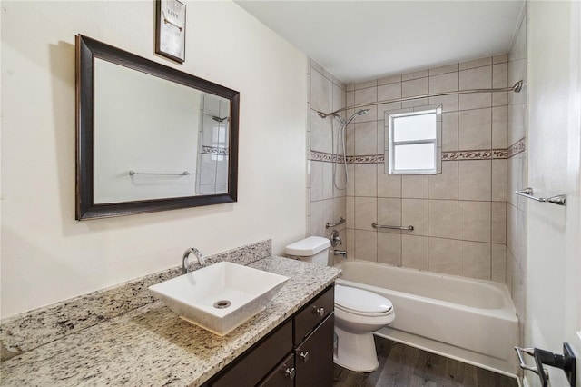 full bathroom featuring vanity, wood-type flooring, toilet, and tiled shower / bath